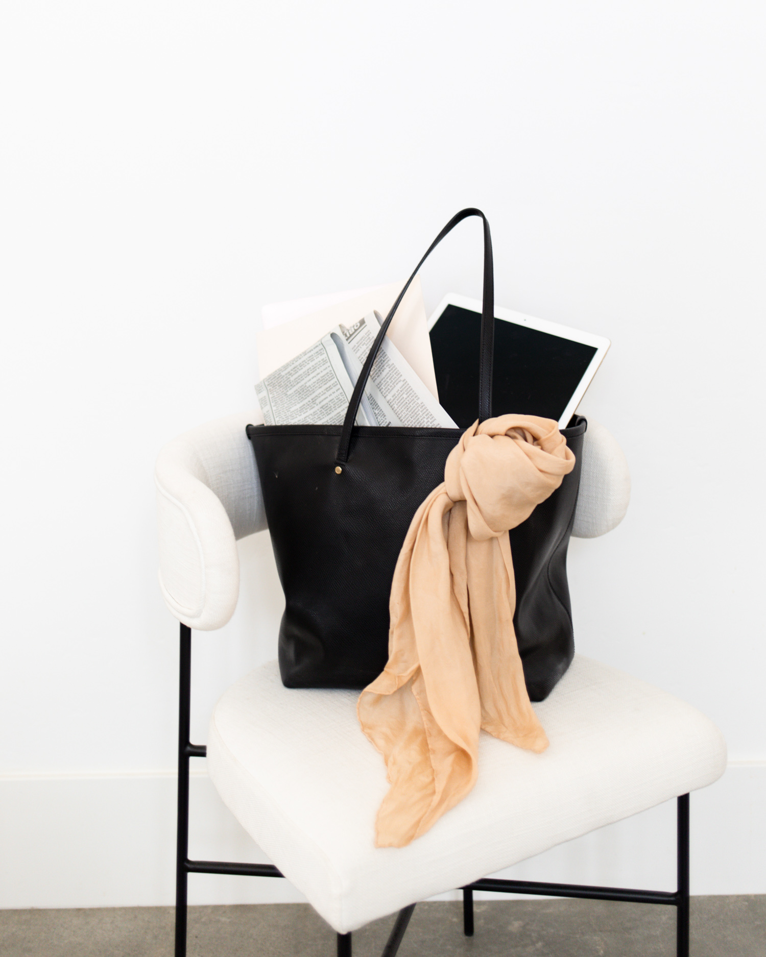 Tote bag in a chair with newspaper and scarf